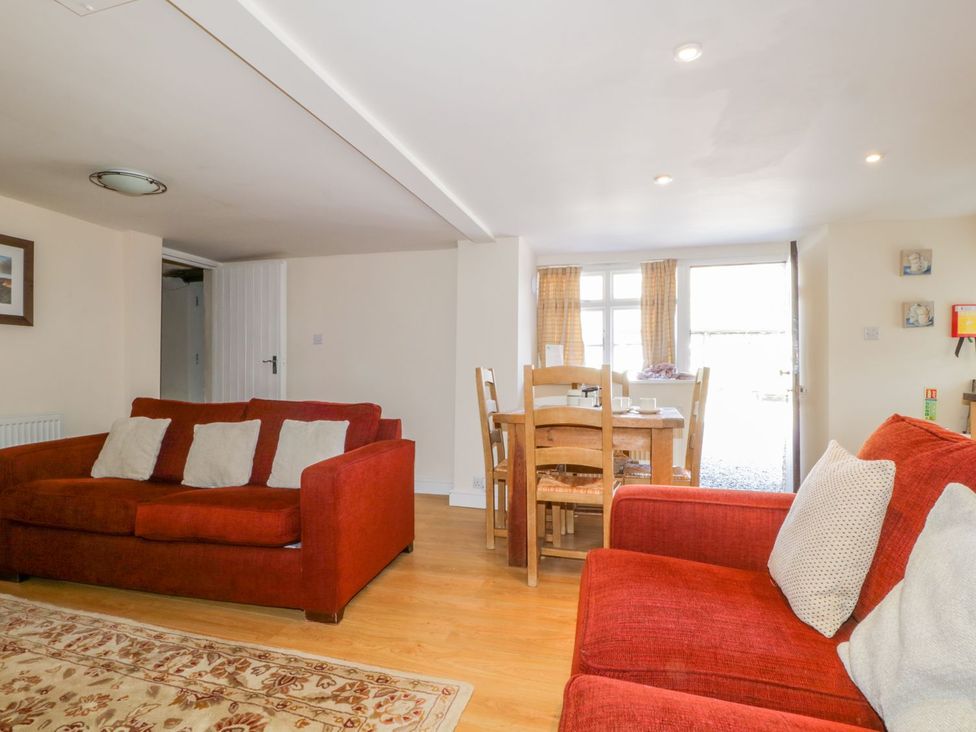 A living room with a sofa and dining table at Farmhouse Cottage in Keswick