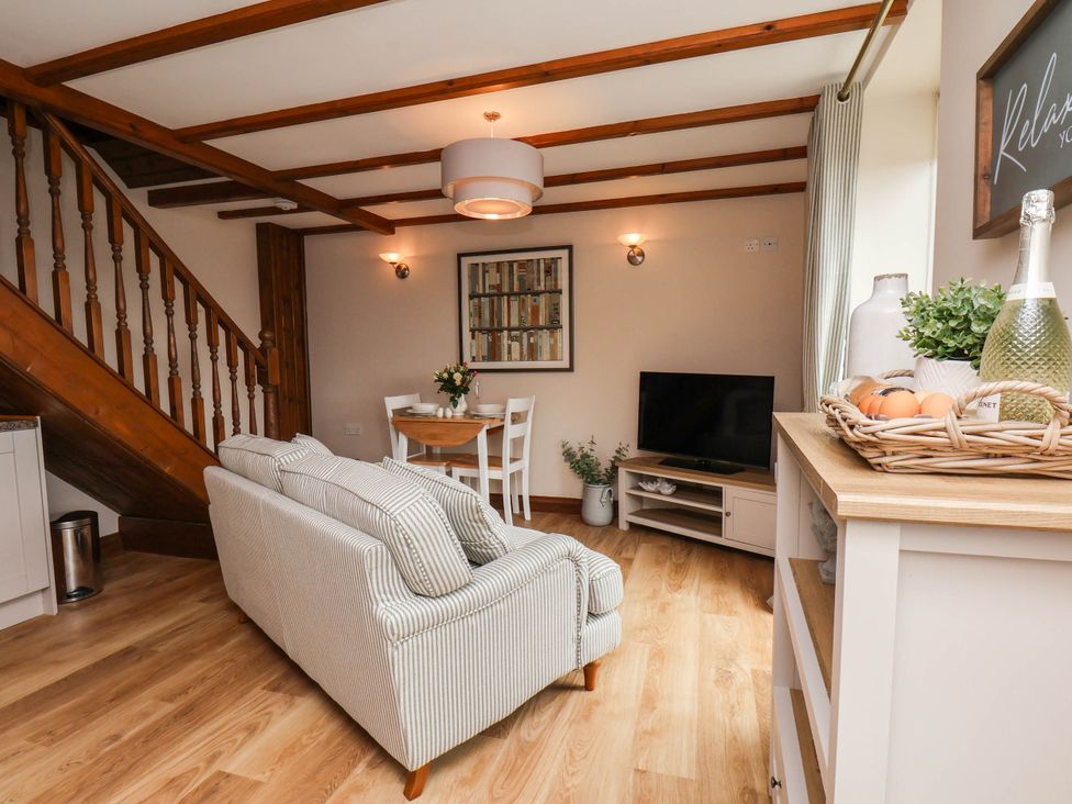 A living room with a sofa and dining table at Wren's Nest in Lealholm