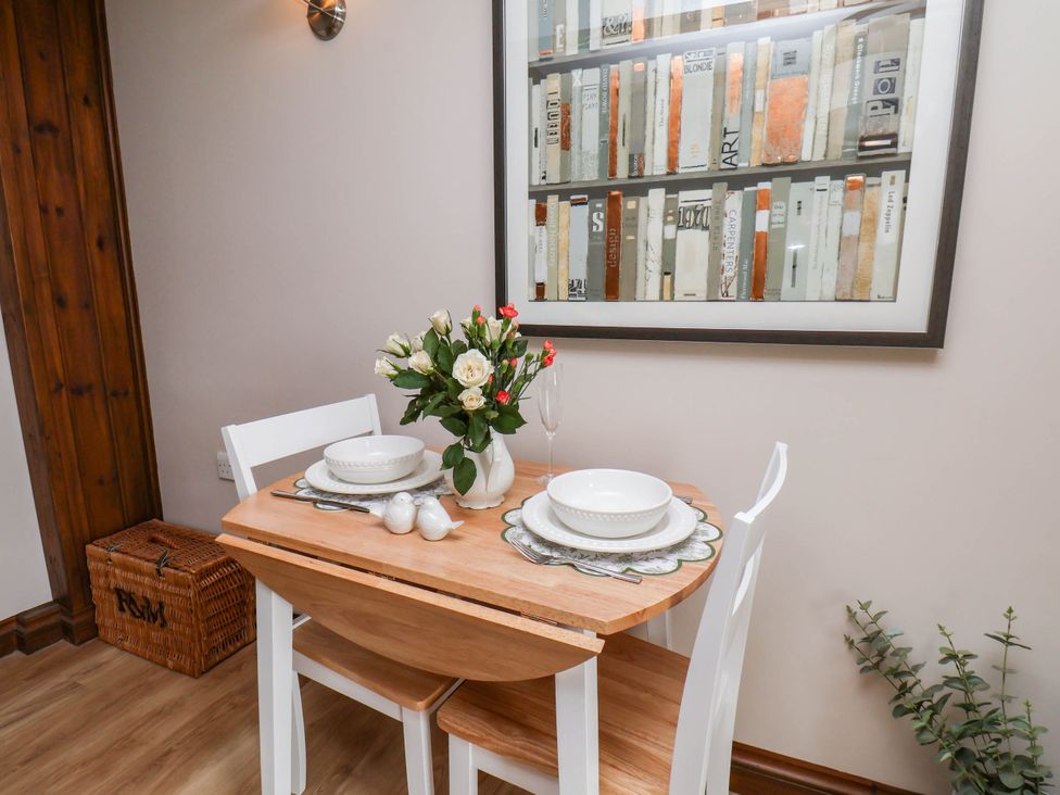 A dining table set with flowers and plates at Wren's Nest in Lealholm