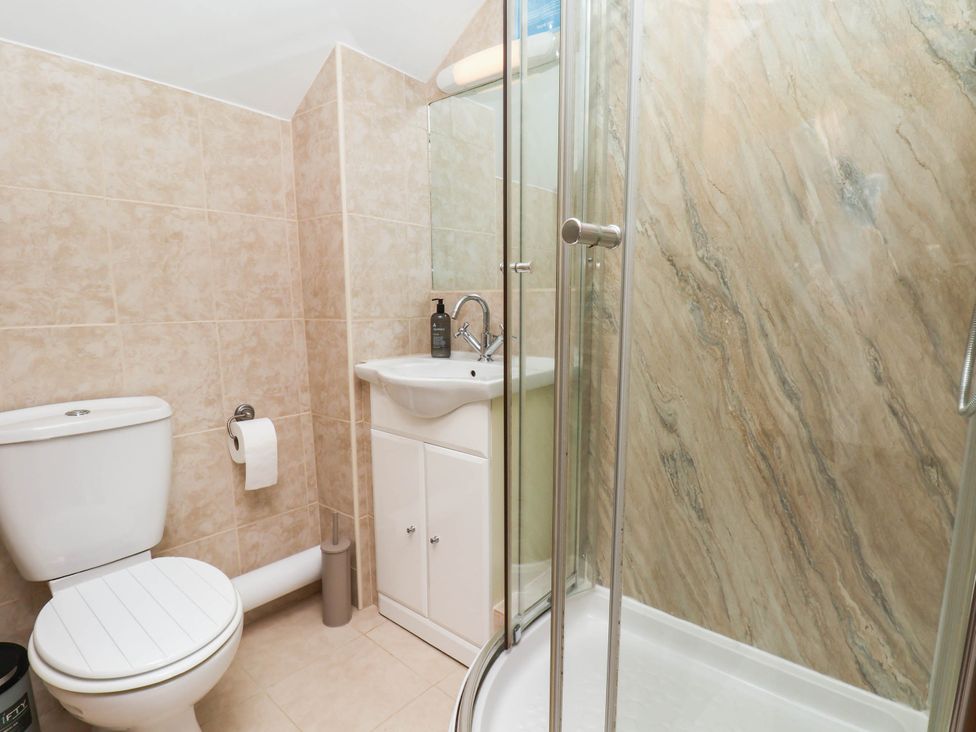 A bathroom with a shower, toilet, and sink at Wren's Nest in Lealholm