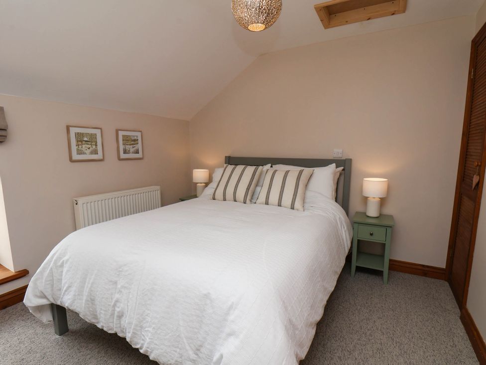 A bedroom with a bed and bedside table at Swallow Cottage in Lealholm