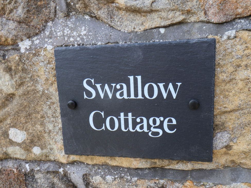 A slate sign reading Swallow Cottage at Swallow Cottage in Lealholm