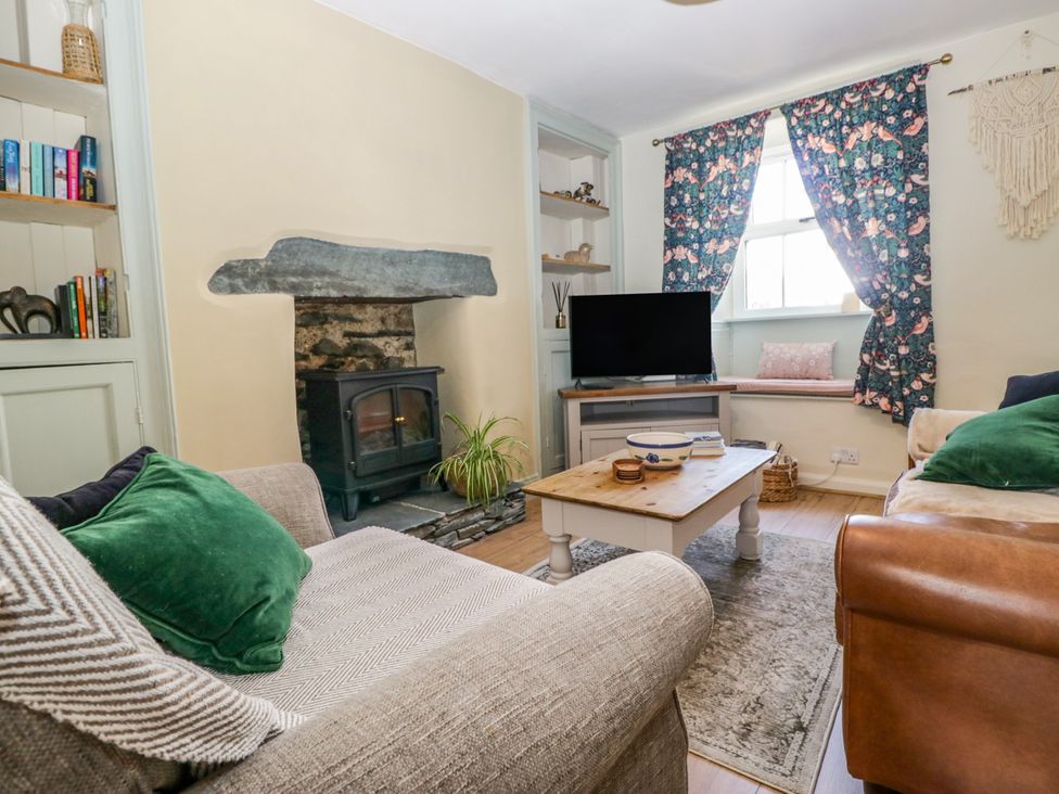 A living room with a fireplace and a coffee table at Bobbin Nook