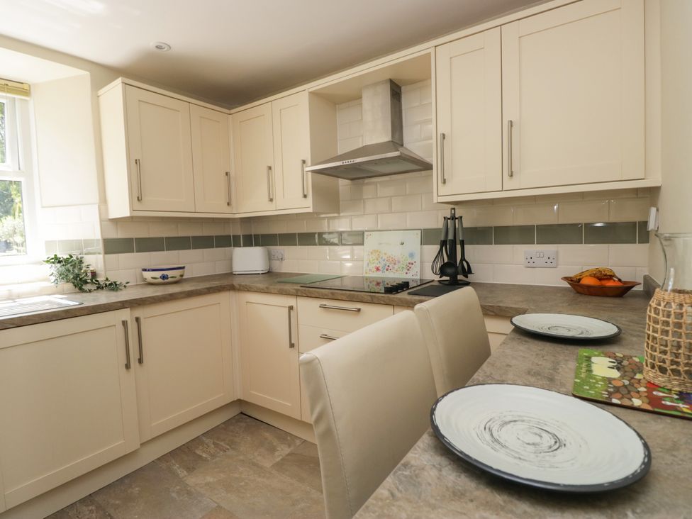 A kitchen with cabinets and stove at Bobbin Nook