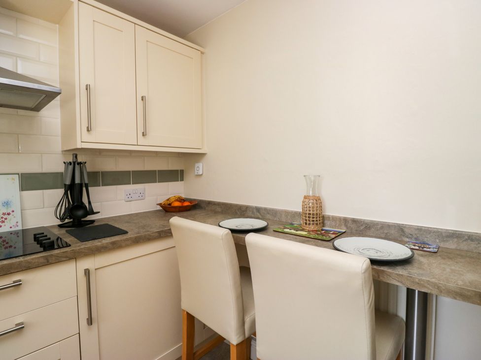 A kitchen with counter space and bar stools at Bobbin Nook