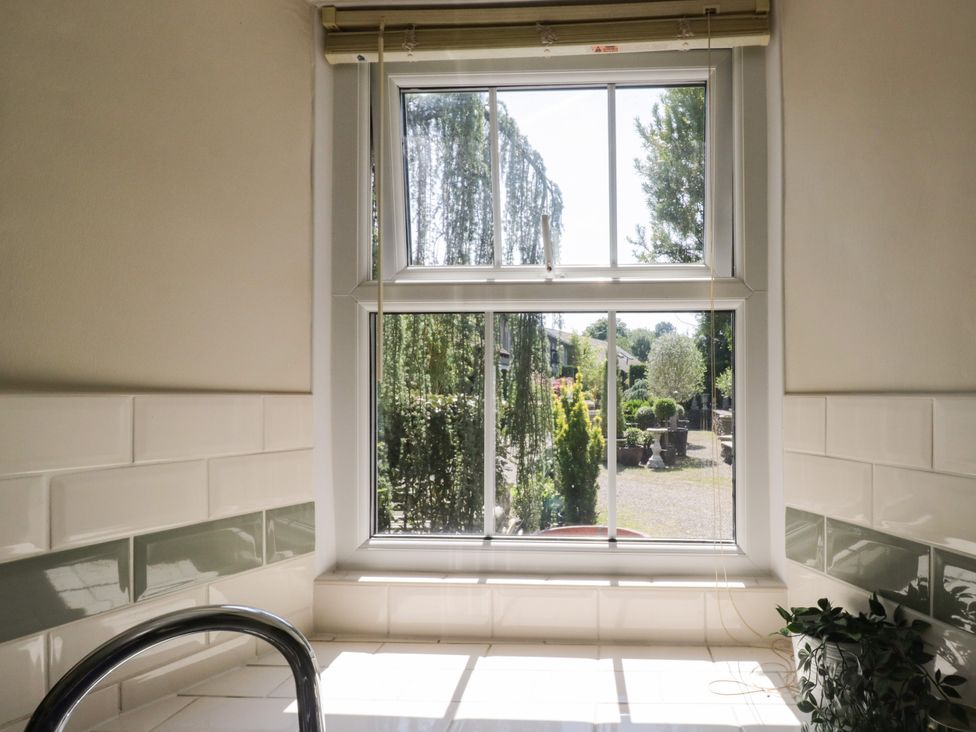 A bathroom with a window showing a garden at Bobbin Nook