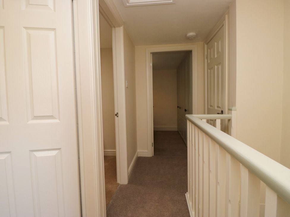 A hallway with doors and carpet at Bobbin Nook