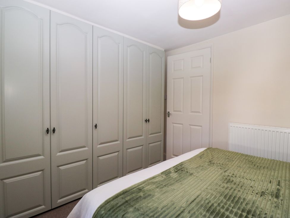A bedroom with a wardrobe and a bed at Bobbin Nook