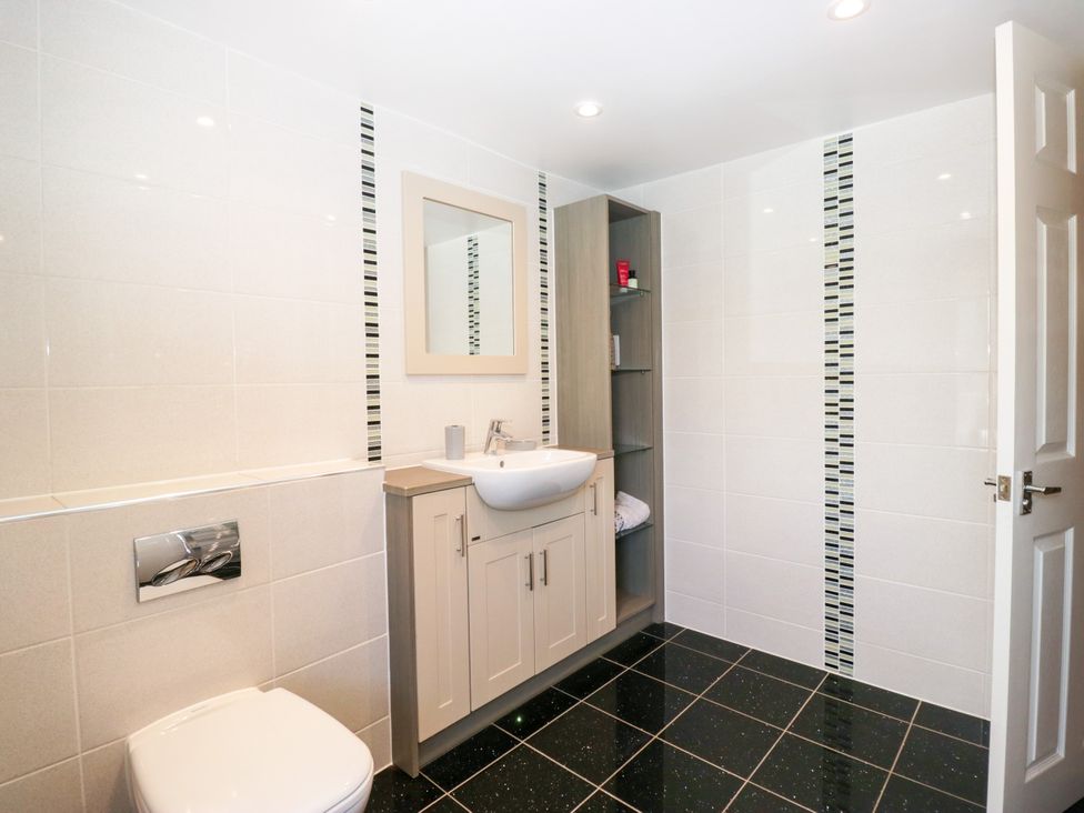 A bathroom with a sink, toilet and mirror at Bobbin Nook