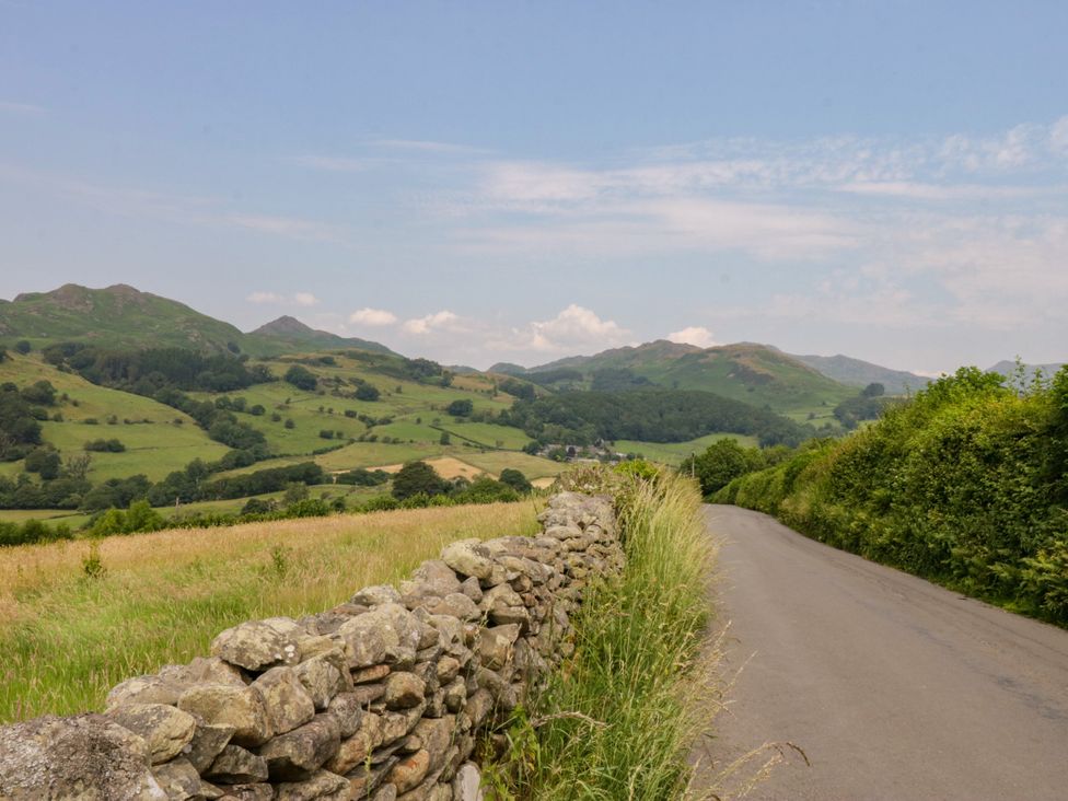 A road beside a stone wall with hills in the background at Bobbin Nook