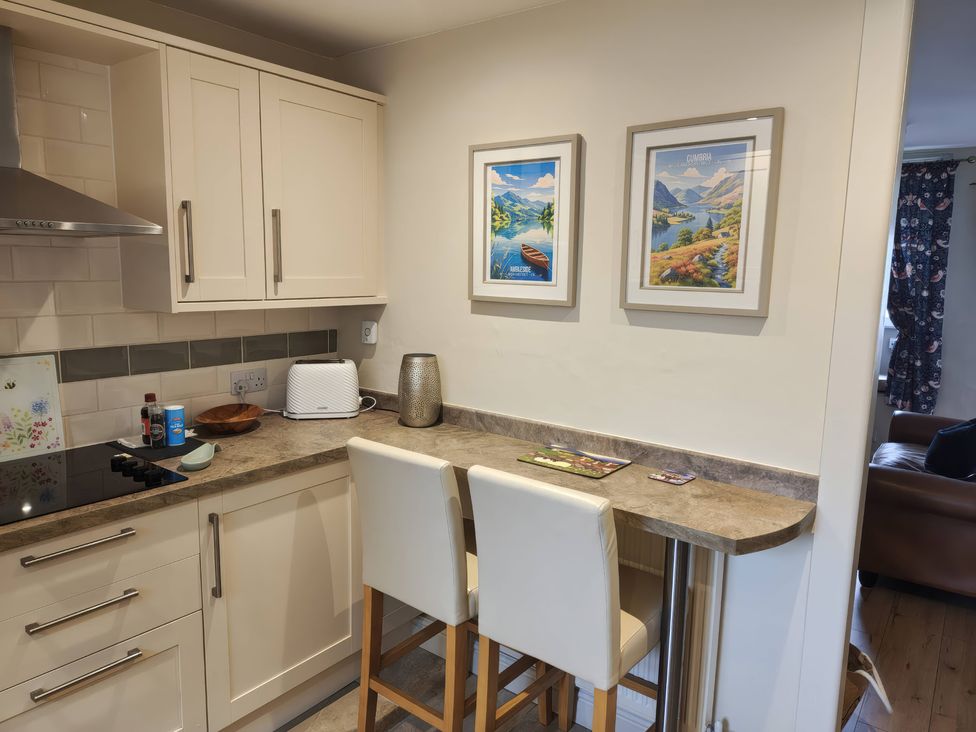 A kitchen with a countertop and bar stools at Bobbin Nook in Staveley