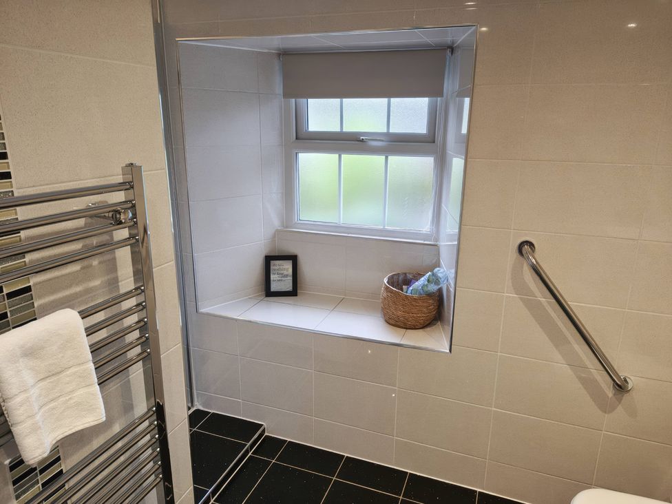 A bathroom with a heated towel rail and a window at Bobbin Nook in Staveley