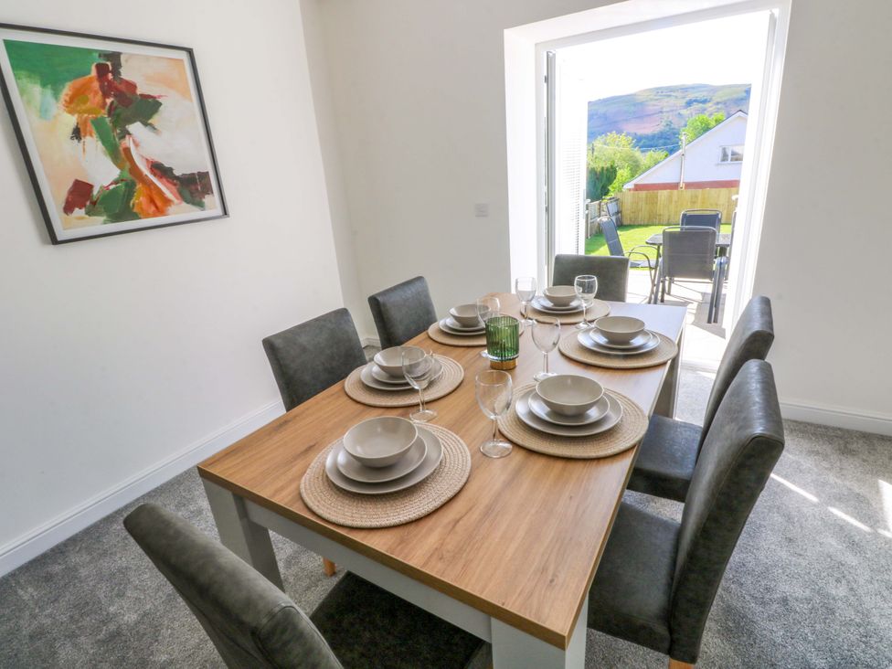 A dining room with a table set for meals at Mountain View Cottage in Ystradgynlais
