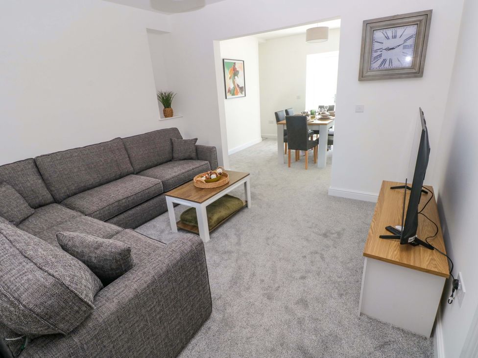 A living room with a sofa and television at Mountain View Cottage Ystradgynlais