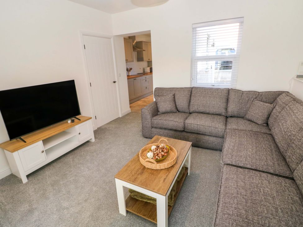 A living room with a sofa, coffee table, and television at Mountain View Cottage Ystradgynlais