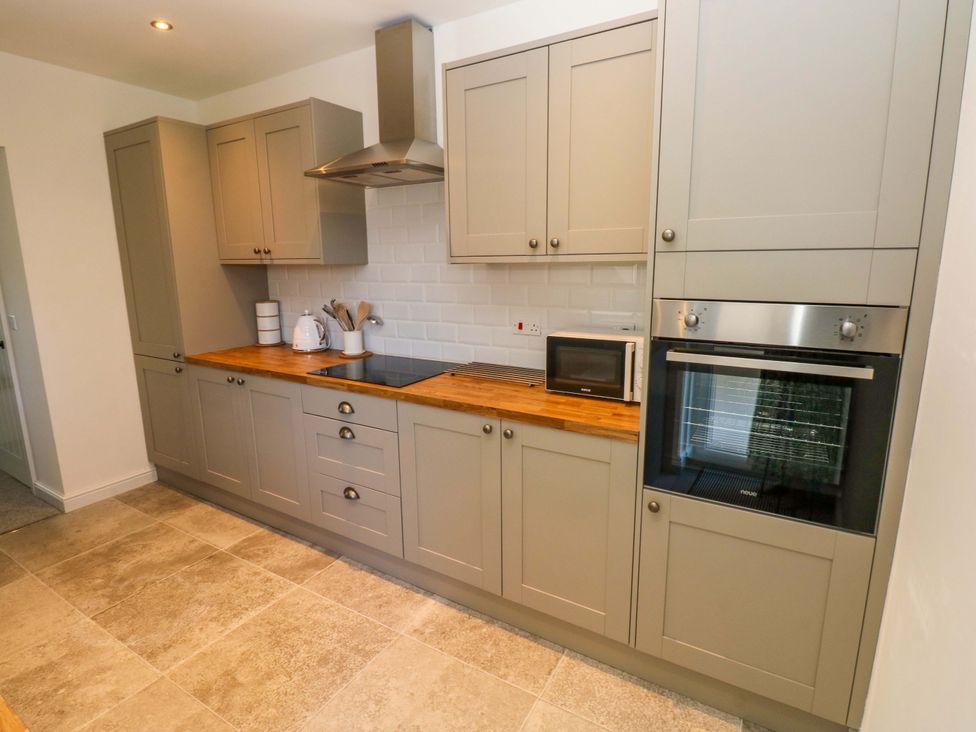 A kitchen with cabinets and appliances at Mountain View Cottage in Ystradgynlais