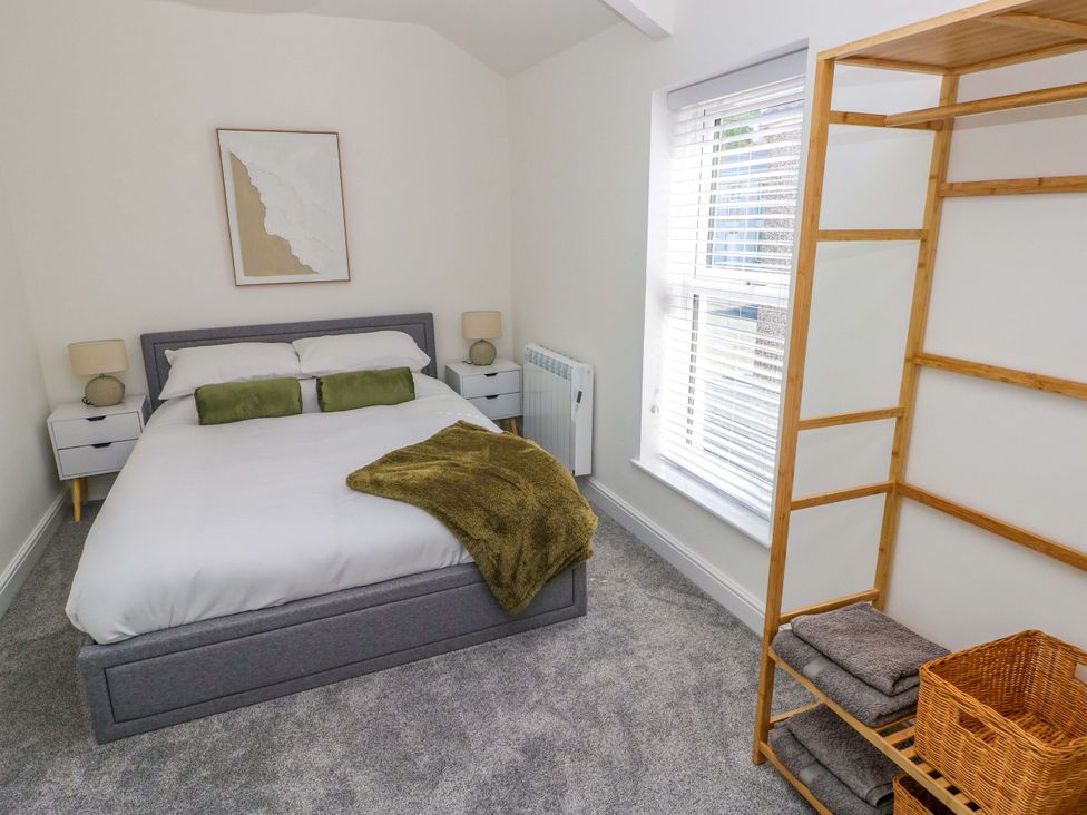 A bedroom with a bed and shelf at Mountain View Cottage in Ystradgynlais