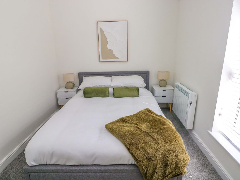 A bedroom with a bed and bedside tables at Mountain View Cottage in Ystradgynlais