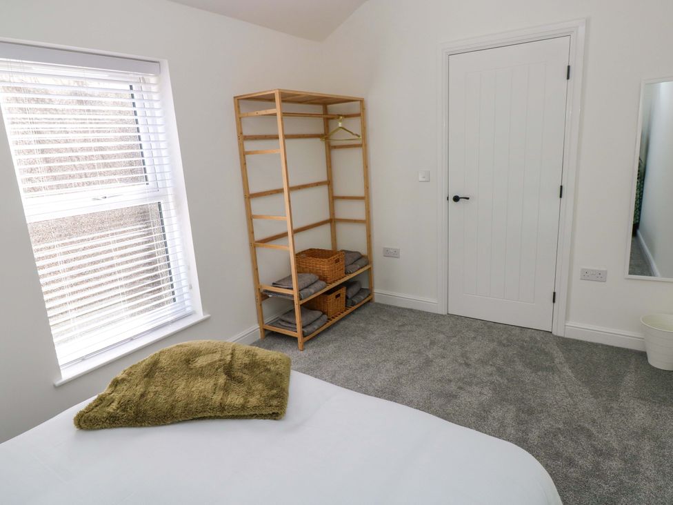 A bedroom with a shelf and door at Mountain View Cottage in Ystradgynlais