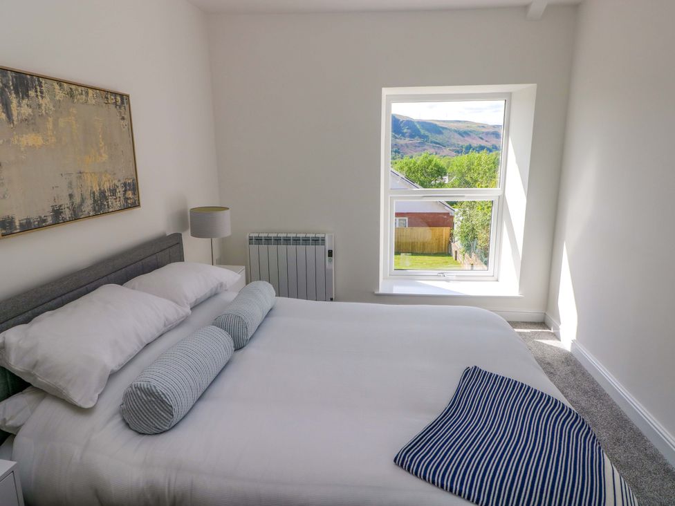 A bedroom with a bed and a window at Mountain View Cottage in Ystradgynlais