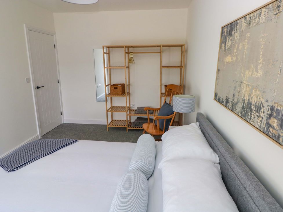 A bedroom with a bed and shelving at Mountain View Cottage in Ystradgynlais
