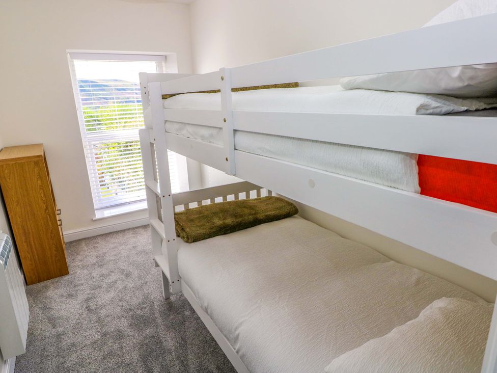 A bedroom with a bunk bed and a wardrobe at Mountain View Cottage in Ystradgynlais