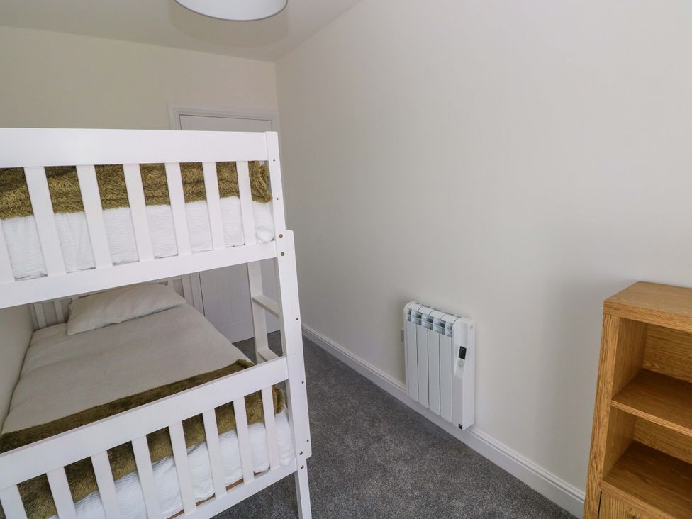 A bedroom with a bunk bed and a heater at Mountain View Cottage in Ystradgynlais