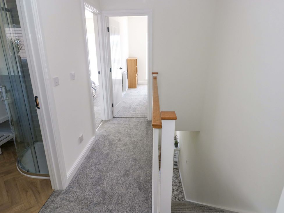 A hallway with doors and staircase at Mountain View Cottage in Ystradgynlais