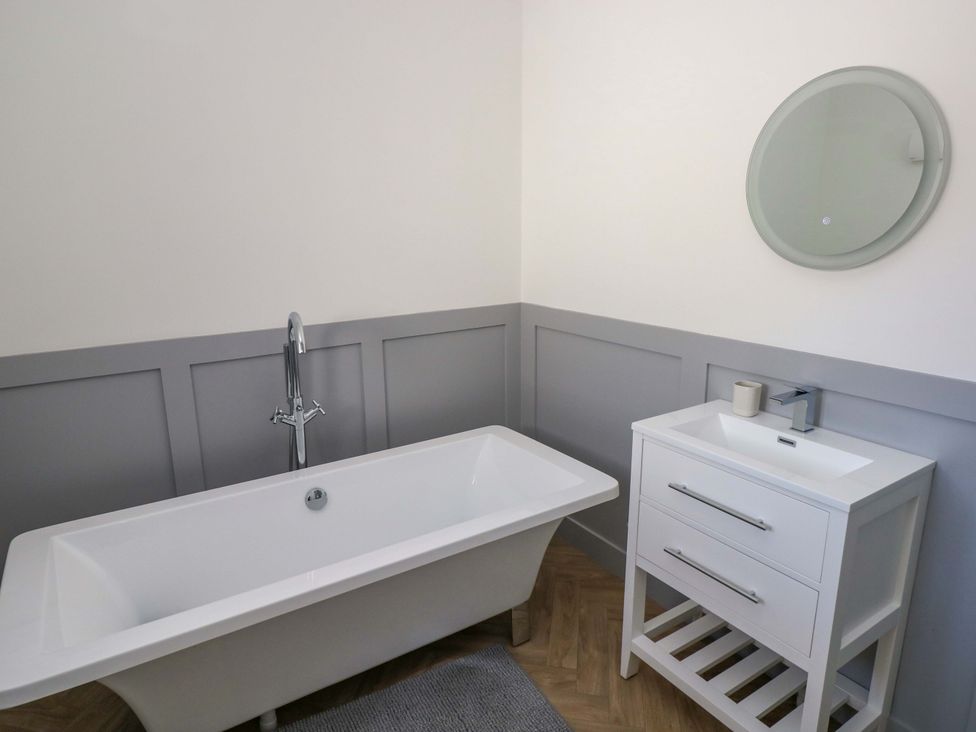 A bathroom with a bathtub and sink at Mountain View Cottage Ystradgynlais