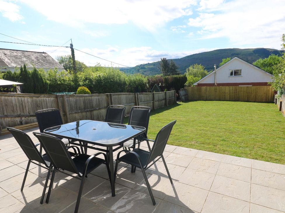 A garden with a table and chairs at Mountain View Cottage in Ystradgynlais