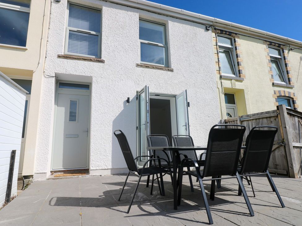 An outdoor seating area with a table and chairs at Mountain View Cottage Ystradgynlais