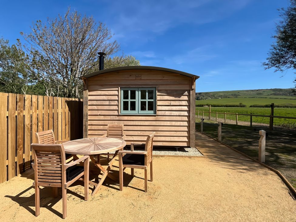 A cabin with a table and chairs outside at The Orchard in Ringstead