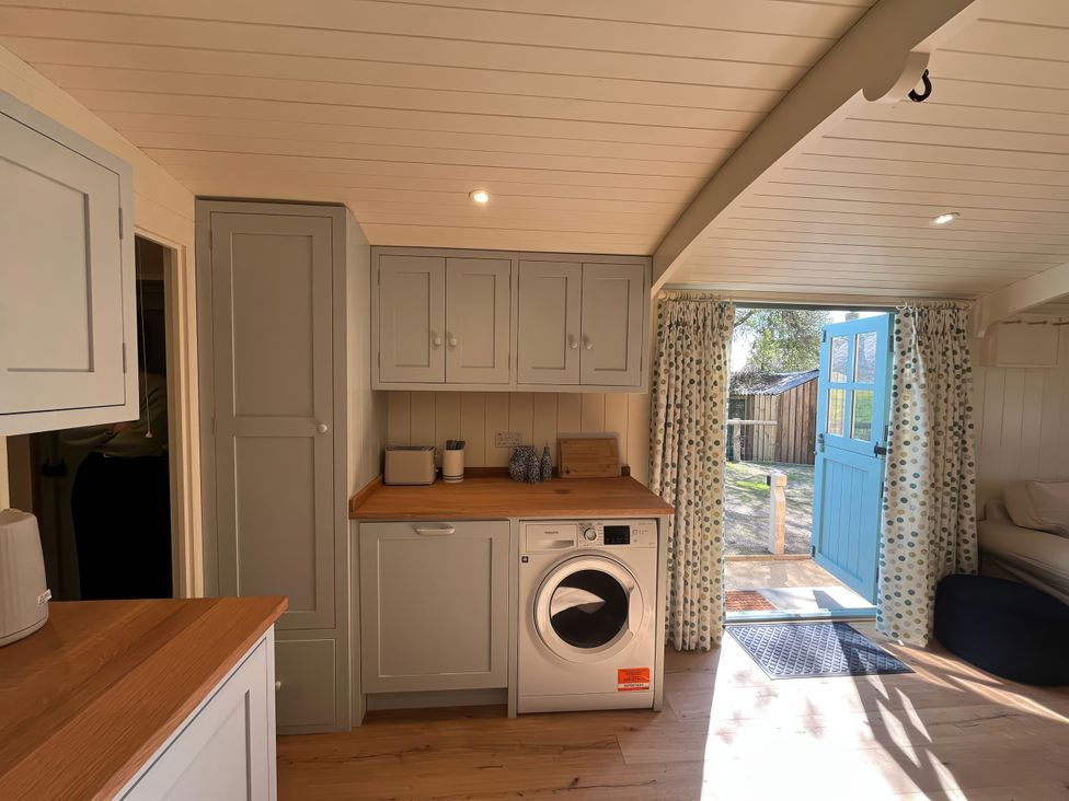 A laundry area with a washing machine and cabinets at The Orchard in Ringstead