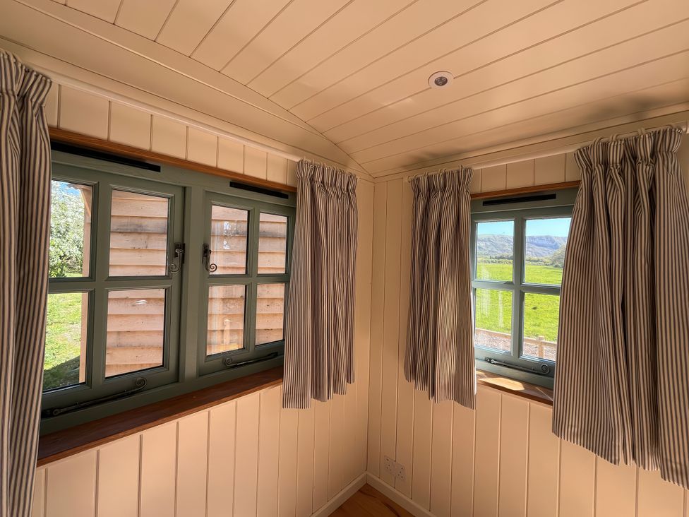 A room with two windows and striped curtains at The Orchard in Ringstead