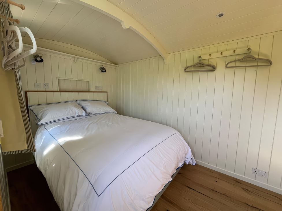 A bedroom with a bed and hangers at The Orchard in Ringstead