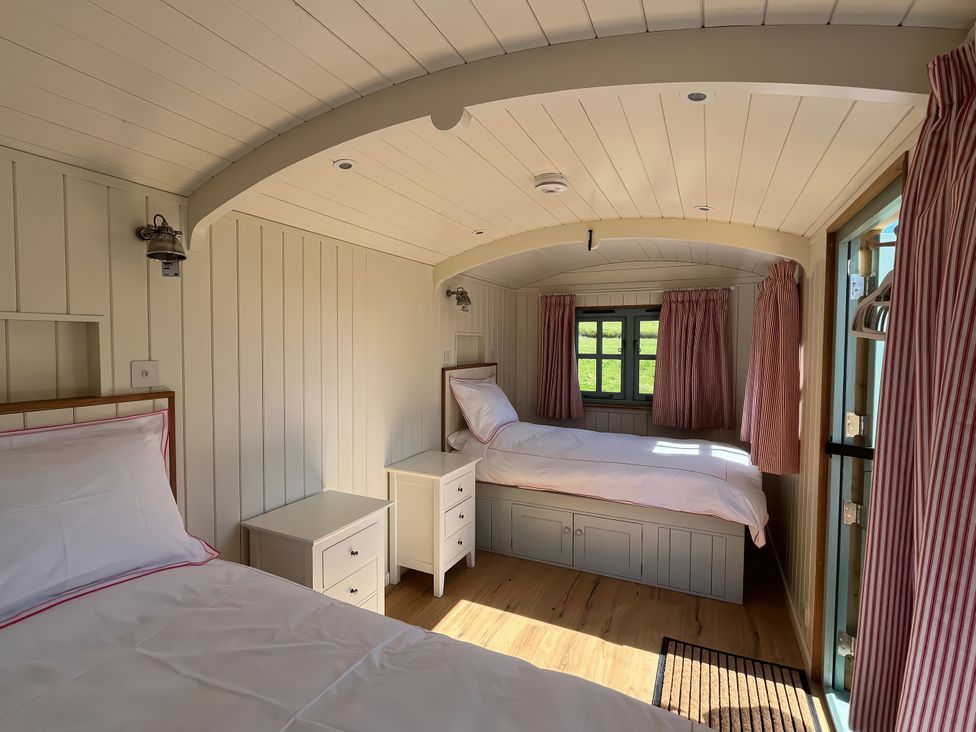 A bedroom with two beds and a window at The Orchard in Ringstead