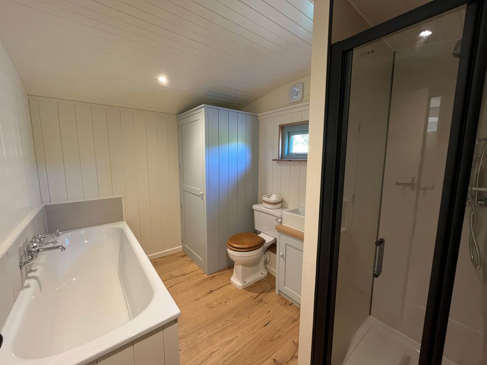 A bathroom with a bathtub, toilet, sink and shower at The Orchard in Ringstead