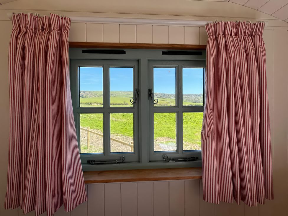 A window with striped curtains and a view at The Orchard in Ringstead