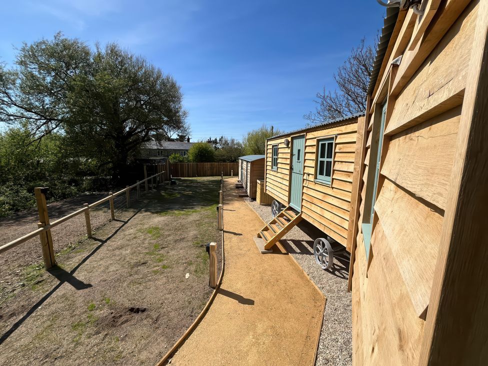 A pathway leading to a wooden cabin at The Orchard in Ringstead