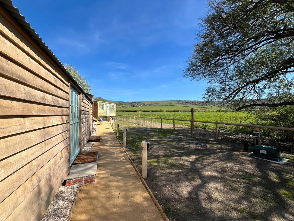 An outdoor view with wooden cabins and a pathway at The Orchard in Ringstead