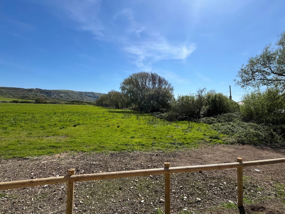 A field with trees and hills at The Orchard in Ringstead