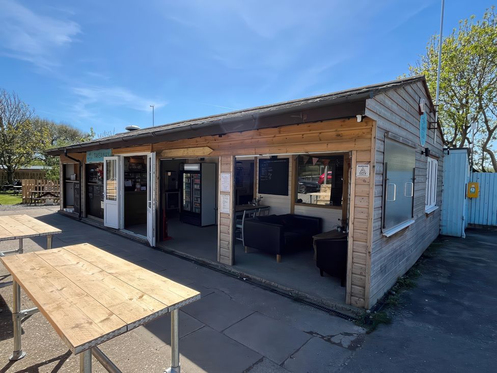 An outdoor area with tables and a wooden building at The Orchard in Ringstead