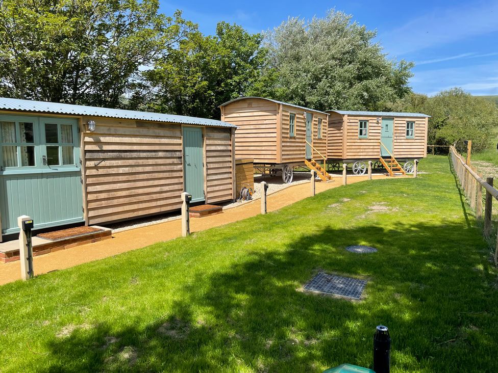 Three wooden caravans in an outdoor area at The Orchard in Ringstead