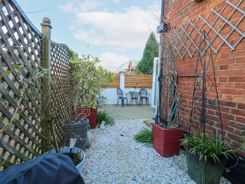 A garden with a table and chairs at Hideaway Cottage in Hunstanton