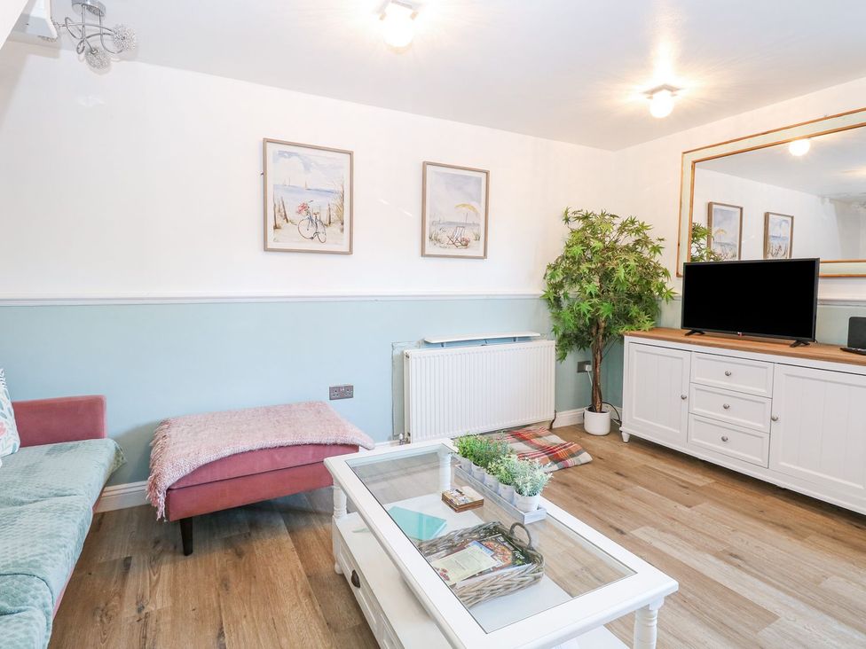 A living room with a television and sofa at Hideaway Cottage in Hunstanton
