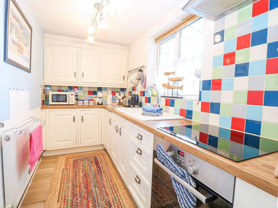 A kitchen with a microwave and oven at Hideaway Cottage in Hunstanton