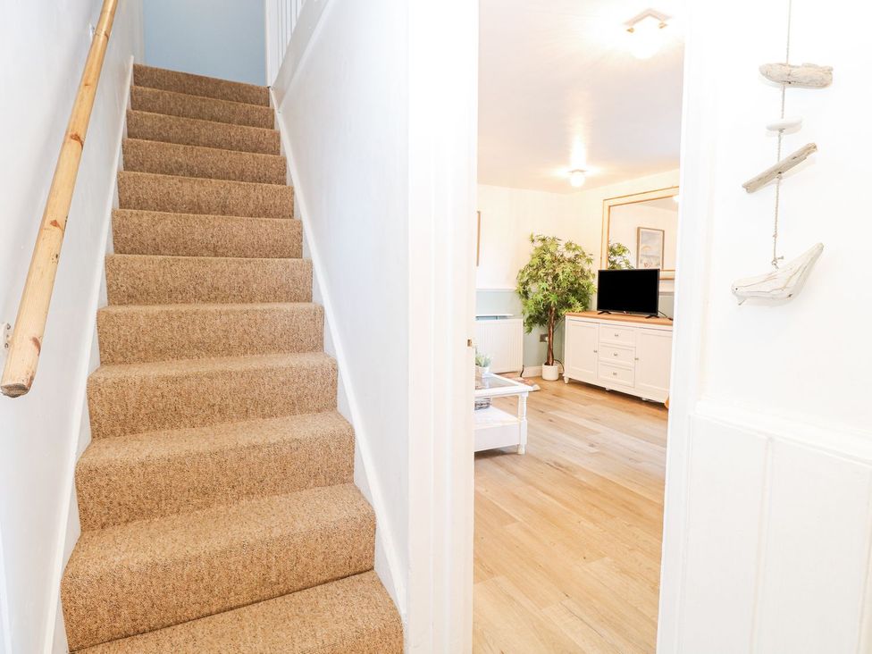 A staircase leading to a living room area at Hideaway Cottage in Hunstanton