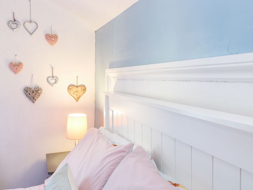 A bedroom with a bed and wall decorations at Hideaway Cottage in Hunstanton