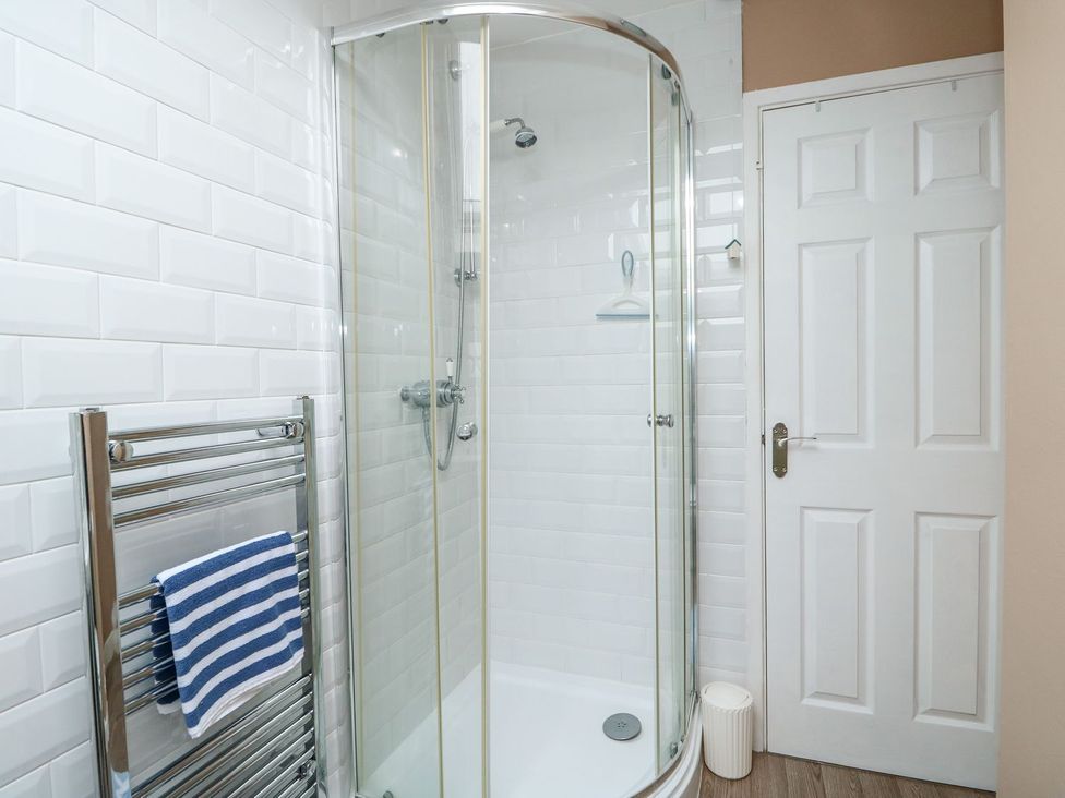 A bathroom with a shower and towel rail at Hideaway Cottage Hunstanton