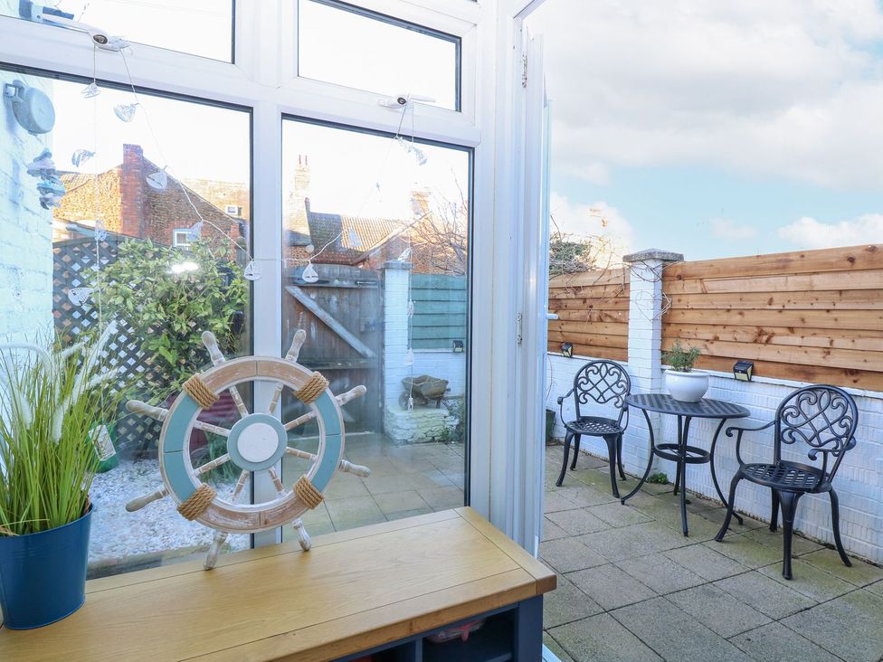 A conservatory with a table and chairs at Hideaway Cottage in Hunstanton